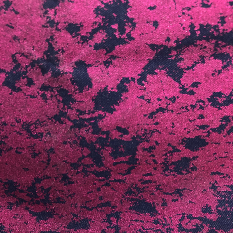 A draped sample of jolt foiled stretch faux denim in the color hot pink.