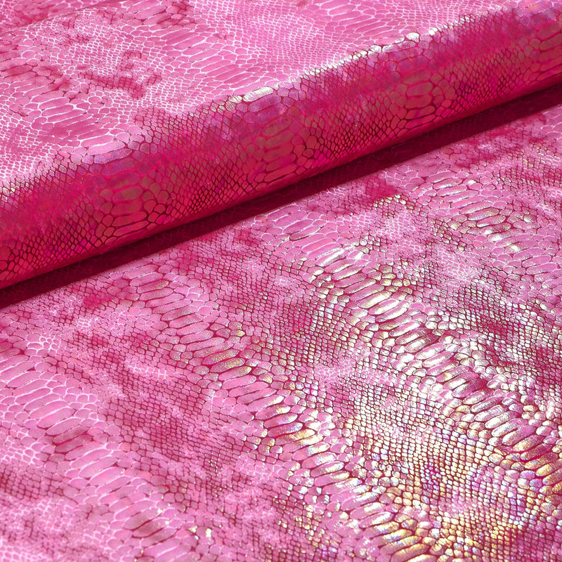 A folded sample of illusion anaconda foil printed stretch velvet in the color pink.