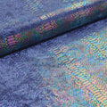 A folded sample of illusion anaconda foil printed stretch velvet in the color navy.