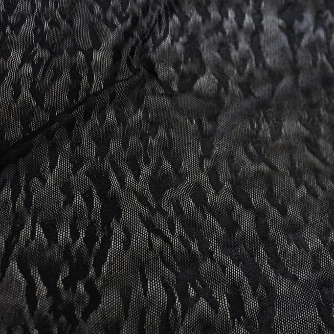 A flat sample of impressions textured power mesh in the color black.