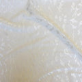 A flat sample of impressions textured power mesh in the color off-white.