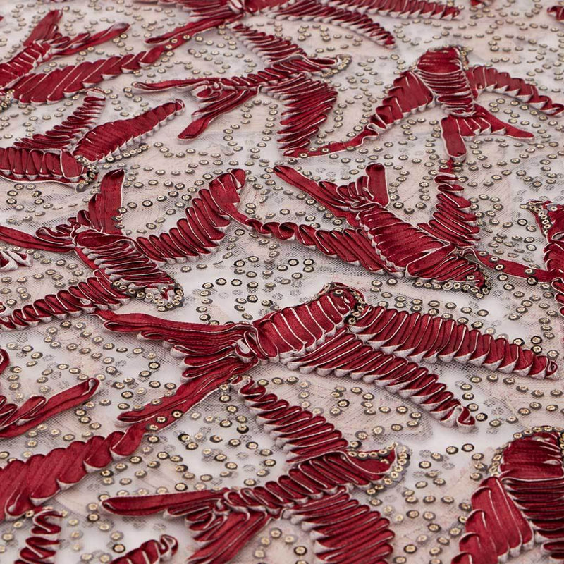 A flat sample of in flight embroidered mesh in the color burgundy-white-gold.