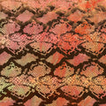 A flat sample of jungle cobra foil printed stretch velvet in the color orange.