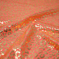 Detailed shot of Loud Leo Foil Printed Spandex in Coral/Gold.