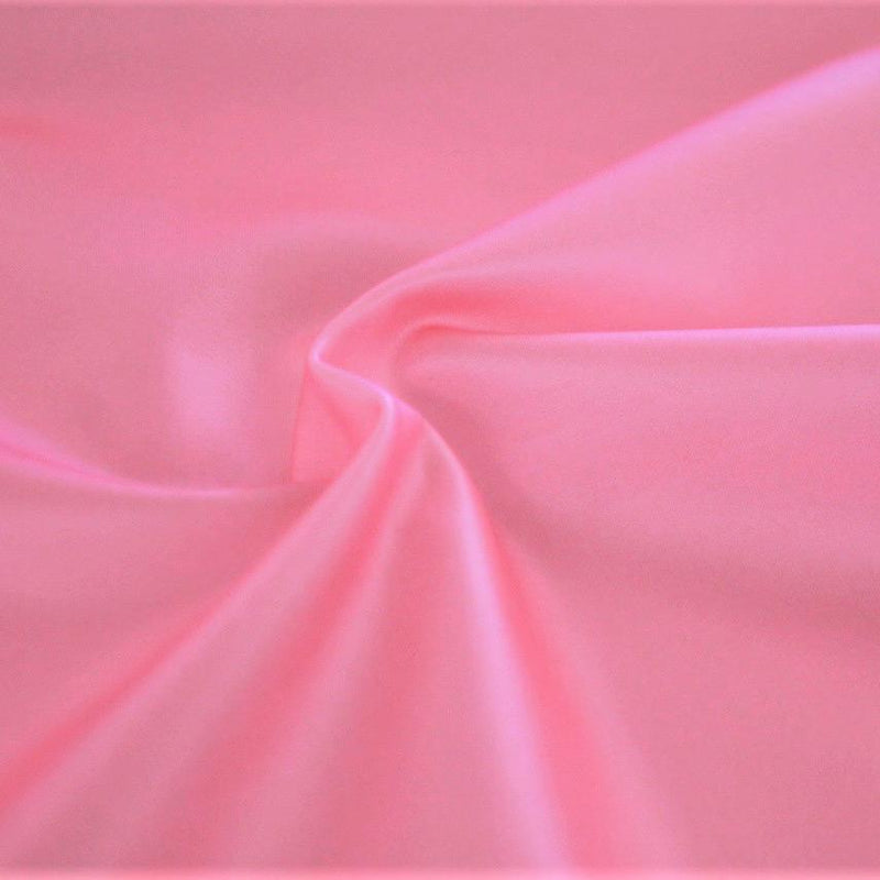 A swirled sample of luster soft foiled spandex in the color bubblegum-pink.