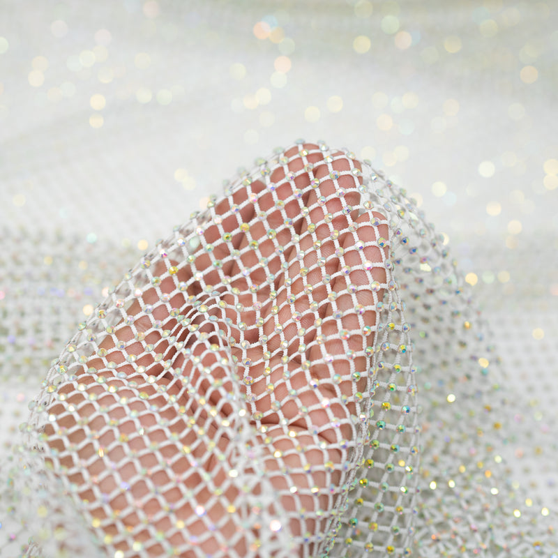 A hand pulling on a sample of Enigma Diamond Fishnet in the color White-Rainbow