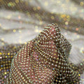 A hand pulling on a sample of Enigma Diamond Fishnet in the color Brown-Rainbow