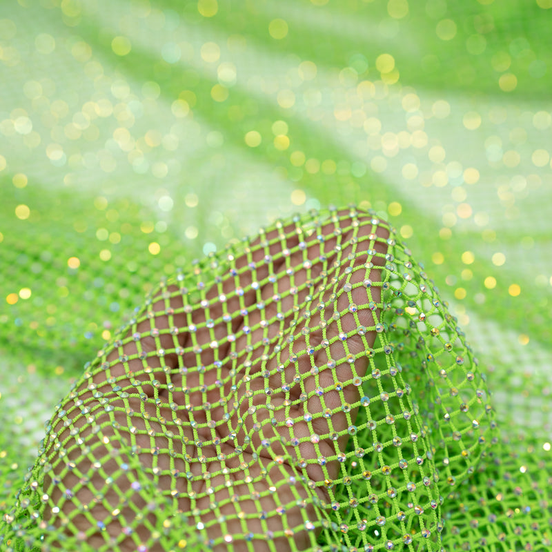 A hand pulling on a sample of Enigma Diamond Fishnet in the color Neon-Green-Rainbow