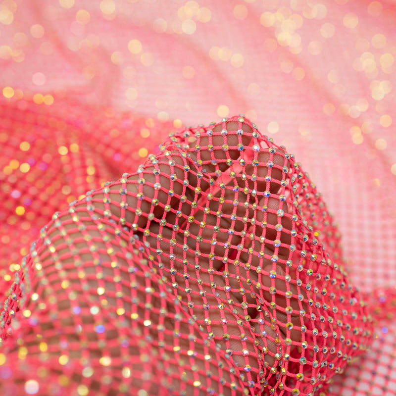 A hand pulling on a sample of Enigma Diamond Fishnet in the color Neon-Pink-Rainbow