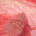 A hand pulling on a sample of Enigma Diamond Fishnet in the color Neon-Pink-Rainbow