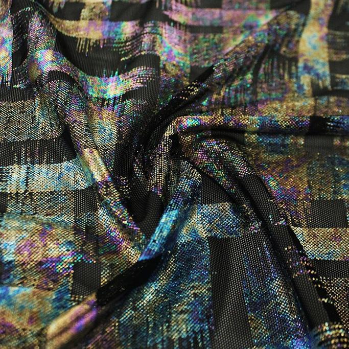 A swirled sample of madras foil printed stretch mesh in the color black-blue-purple-gold.