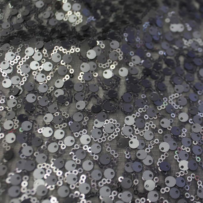 A swirled sample of marilyn stretch meh sequin in the color charcoal.