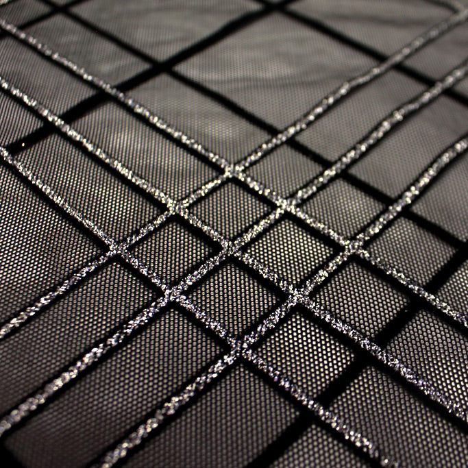 A flat sample of mary jane glitter stretch mesh in the color black-silver.