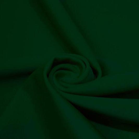 A swirled piece of matte nylon spandex fabric in the color alpine green.