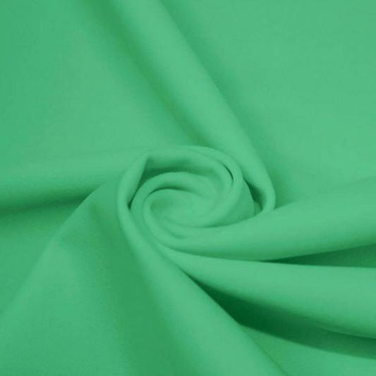A swirled piece of matte nylon spandex fabric in the color aqua green.