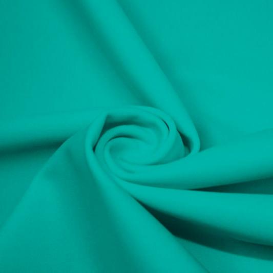 A swirled piece of matte nylon spandex fabric in the color aqua tides.