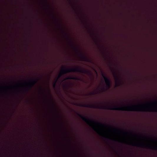 A swirled piece of matte nylon spandex fabric in the color aubergine.