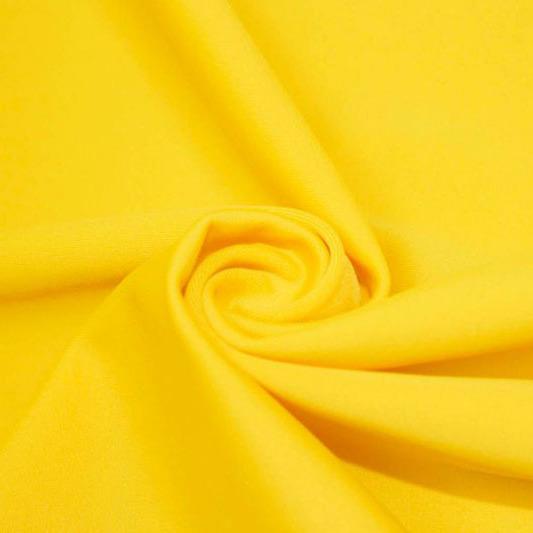 A swirled piece of matte nylon spandex fabric in the color aurora yellow.