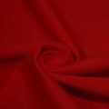 A swirled piece of matte nylon spandex fabric in the color blood red.