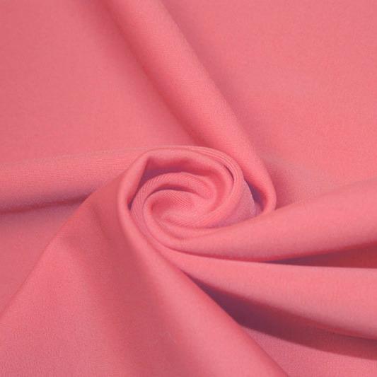 A swirled piece of matte nylon spandex fabric in the color blossom pink.