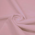 A swirled piece of matte nylon spandex fabric in the color blush.