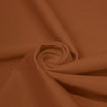 A swirled piece of matte nylon spandex fabric in the color bronze.