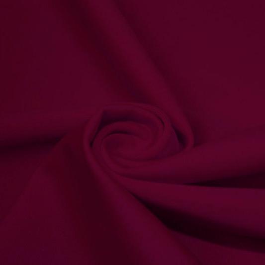 A swirled piece of matte nylon spandex fabric in the color ebi burgundy.