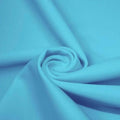 A swirled piece of matte nylon spandex fabric in the color cabo blue.