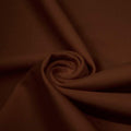 A swirled piece of matte nylon spandex fabric in the color cappuccino.