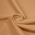 A swirled piece of matte nylon spandex fabric in the color caramel kiss.
