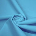 A swirled piece of matte nylon spandex fabric in the color celeste blue.