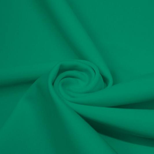 A swirled piece of matte nylon spandex fabric in the color cool green.