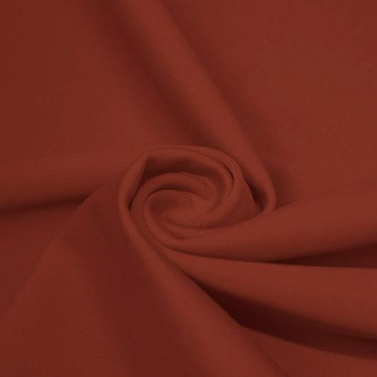 A swirled piece of matte nylon spandex fabric in the color copper.