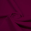 A swirled piece of matte nylon spandex fabric in the color dark berry.