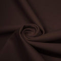 A swirled piece of matte nylon spandex fabric in the color dark brown.