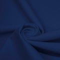 A swirled piece of matte nylon spandex fabric in the color denim.