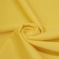A swirled piece of matte nylon spandex fabric in the color duckling yellow.