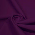 A swirled piece of matte nylon spandex fabric in the color eggplant.