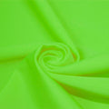 A swirled piece of matte nylon spandex fabric in the color electric lime.