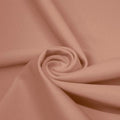 A swirled piece of matte nylon spandex fabric in the color fawn.