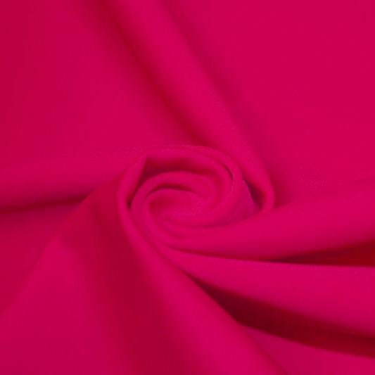 A swirled piece of matte nylon spandex fabric in the color fuchsia.