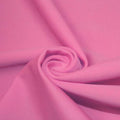 A swirled piece of matte nylon spandex fabric in the color hot pink.