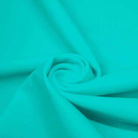 A swirled piece of matte nylon spandex fabric in the color light turquoise.