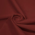 A swirled piece of matte nylon spandex fabric in the color mars.