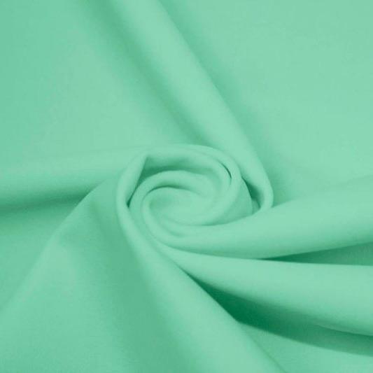 A swirled piece of matte nylon spandex fabric in the color menthol.