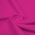 A swirled piece of matte nylon spandex fabric in the color mixed pink.