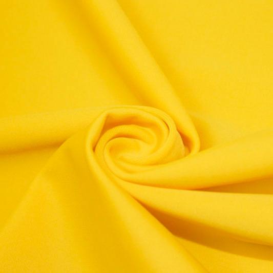 A swirled piece of matte nylon spandex fabric in the color mustard.