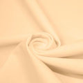 A swirled piece of matte nylon spandex fabric in the color naked.