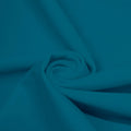 A swirled piece of matte nylon spandex fabric in the color new jade.