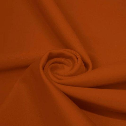 A swirled piece of matte nylon spandex fabric in the color penny.